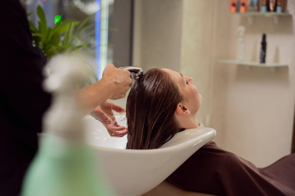 Young blonde woman having salon hair wash. Concept of hair care and hair treatment